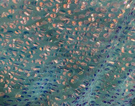 Tejido de tul adornado con lentejuelas holograma cosidas en lila, verde agua y beig.